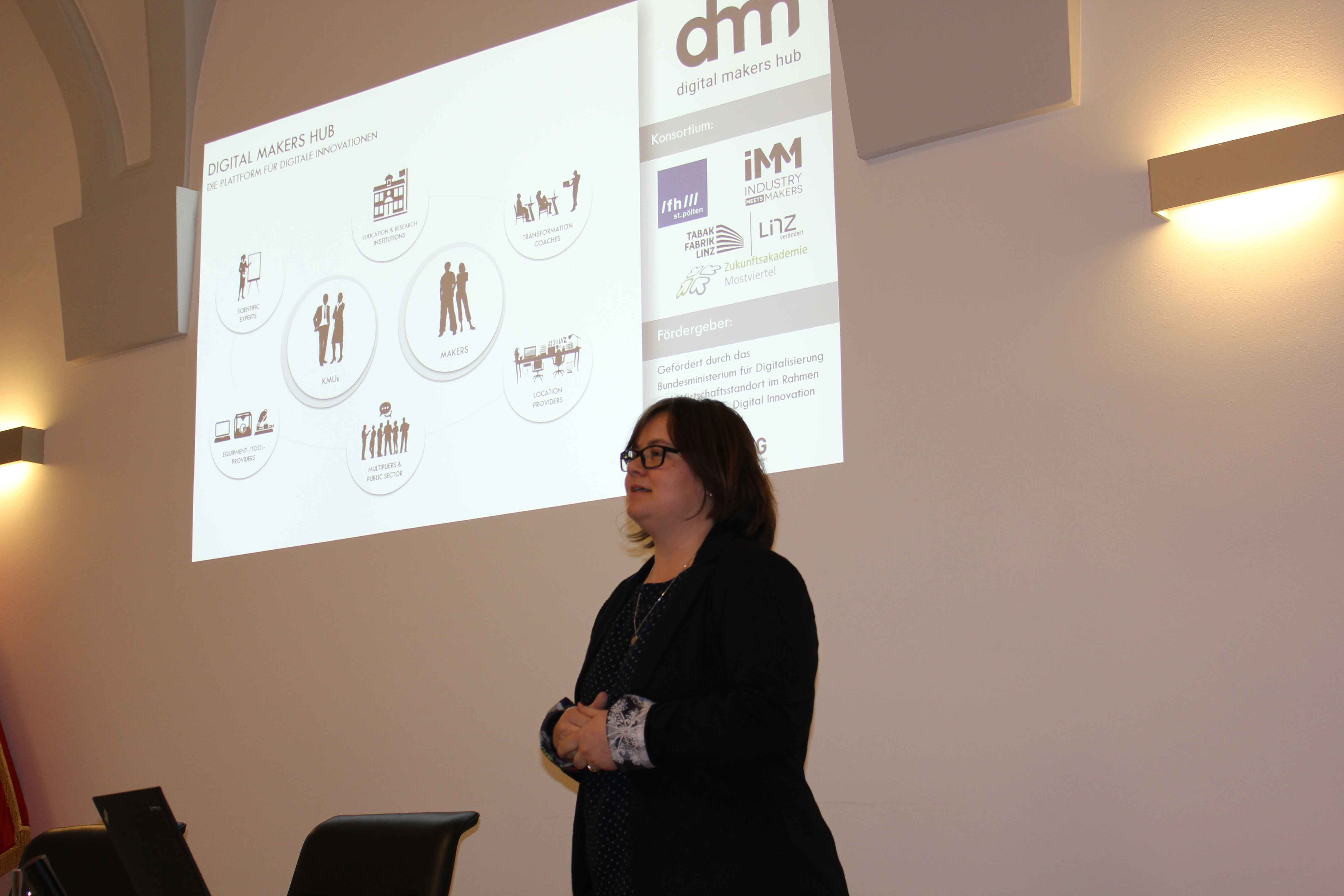 Frau Permoser präsentiert vor einer Leinwand den Digital Makers Hub am SMARTUP Forum