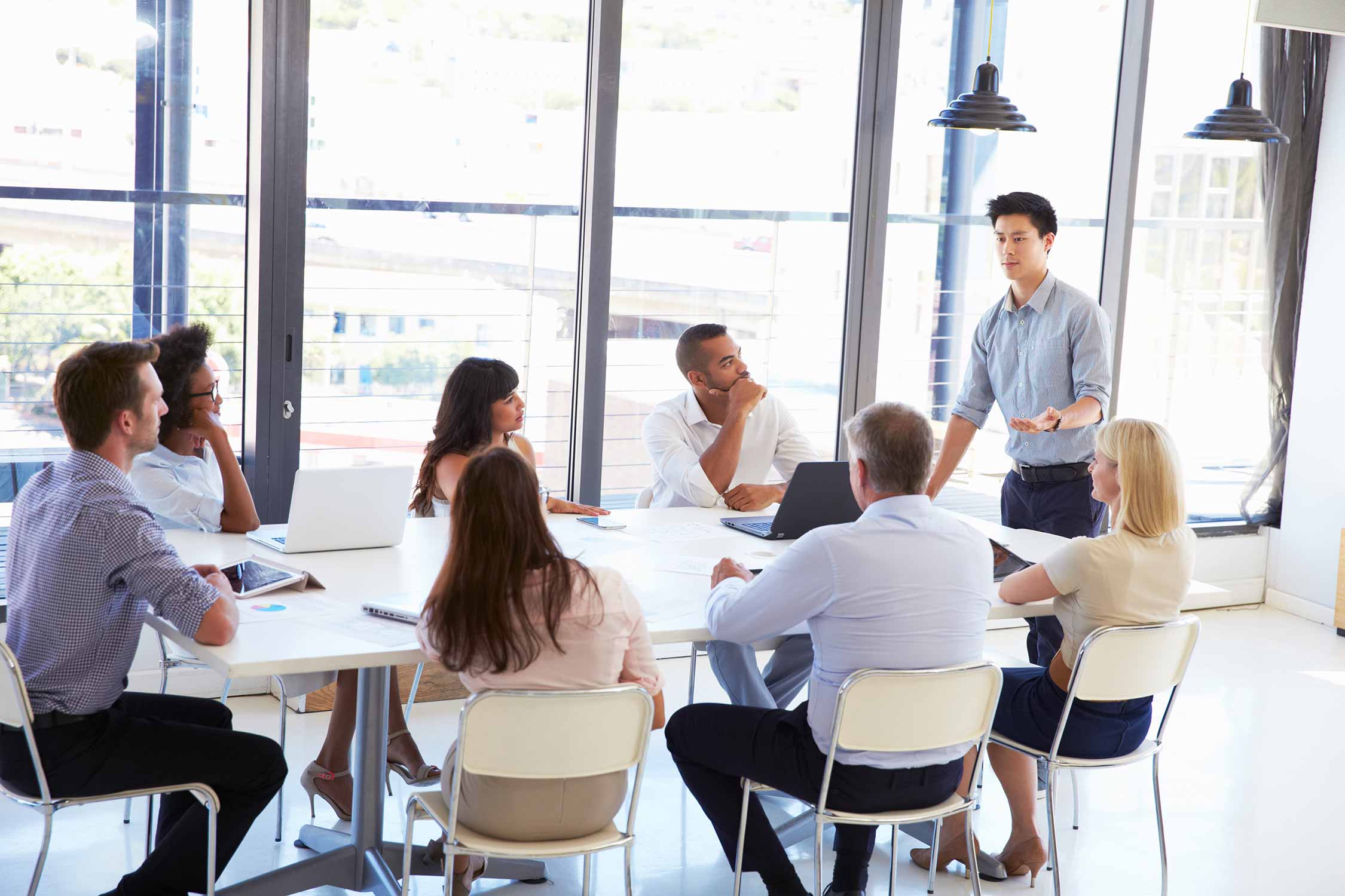 Eine Gruppe an Personen sitzt im Office und hält ein Meeting